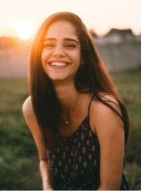 Young woman smiling at sunset after dental services in Catonsville