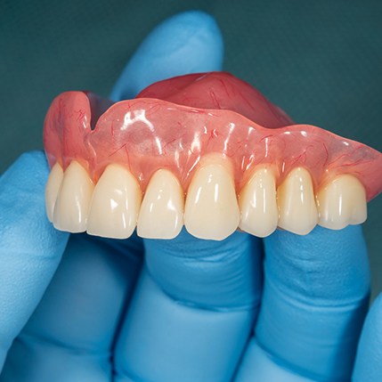 Dentist holding an upper denture