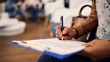 Woman filling out dental insurance form in lobby