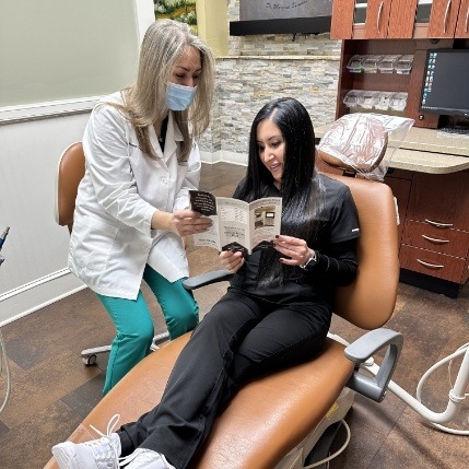 Emergency dentist in Catonsville showing pamphlet to a patient