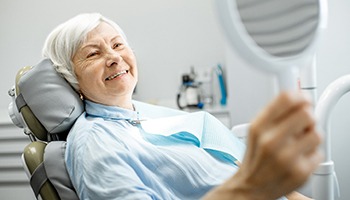 Woman smiling in the dentist’s chair with dental implants