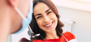 Woman in red blouse smiling at her dentist