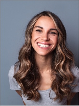 Smiling young woman with curly dirty blonde hair