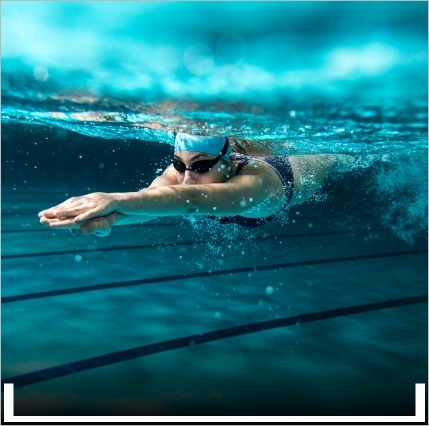 Underwater view of a person swimming with goggles and swim cap