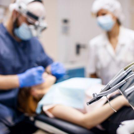 Far away view of two oral surgeons treating a patient