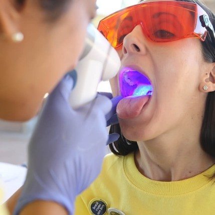 Dentist performing oral cancer screening on a patient