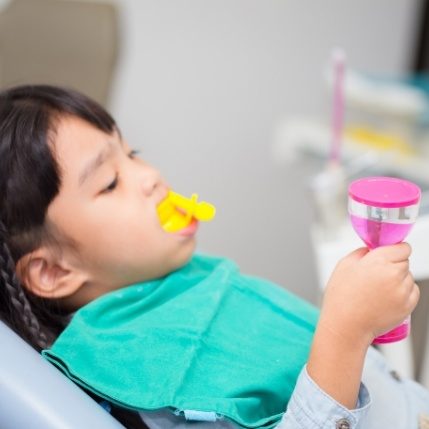 Young child receiving fluoride treatment in dental office