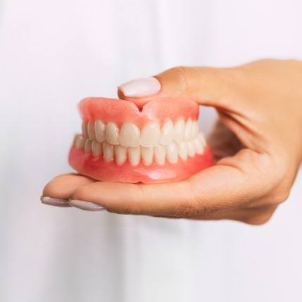 Dentist holding a set of full dentures