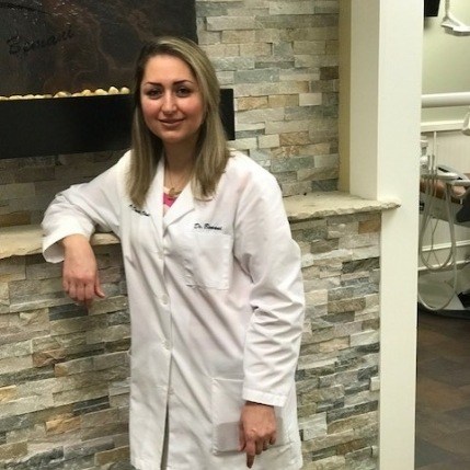 Doctor Bemani leaning against front desk at Advance Dental Clinic