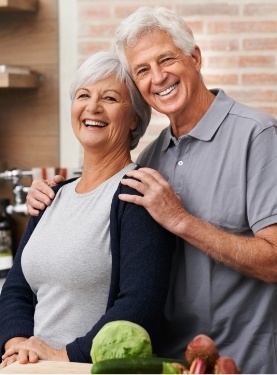 Older man and woman hugging in their kitchen