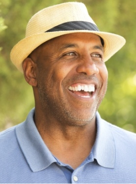 Older man in blue polo shirt grinning outdoors