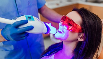 A woman getting in-office teeth whitening at the dentist