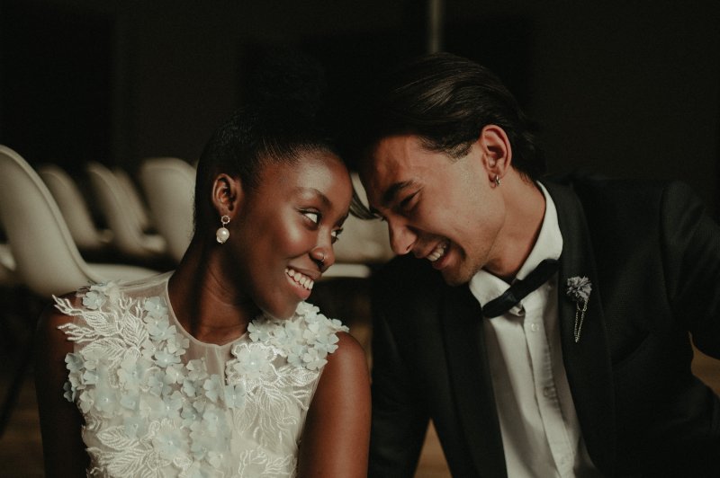 A bride and groom smiling at each other after teeth whitening treatments