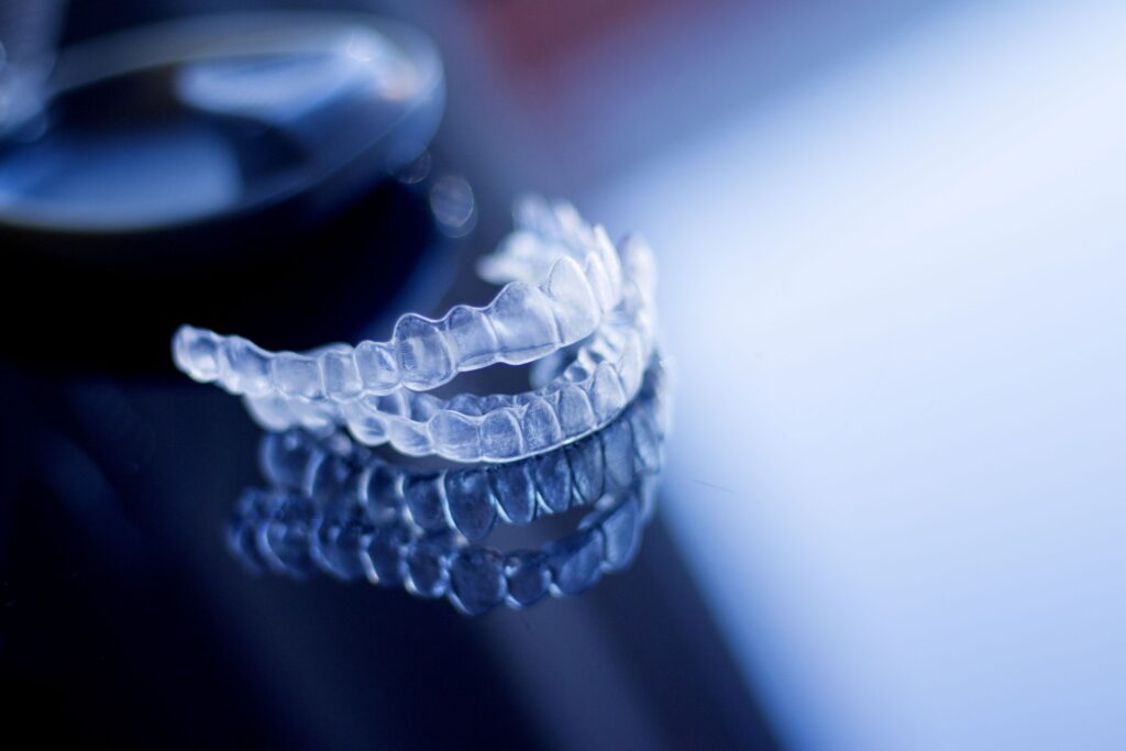 Set of Invisalign trays on dark surface