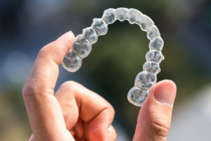Person holding up a clear aligner